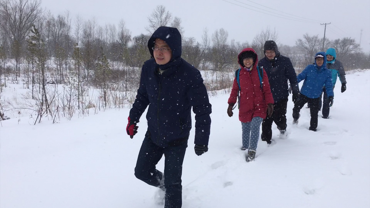 Dr. Xinlei Guo and his team walking with difficulty in heavy snow
